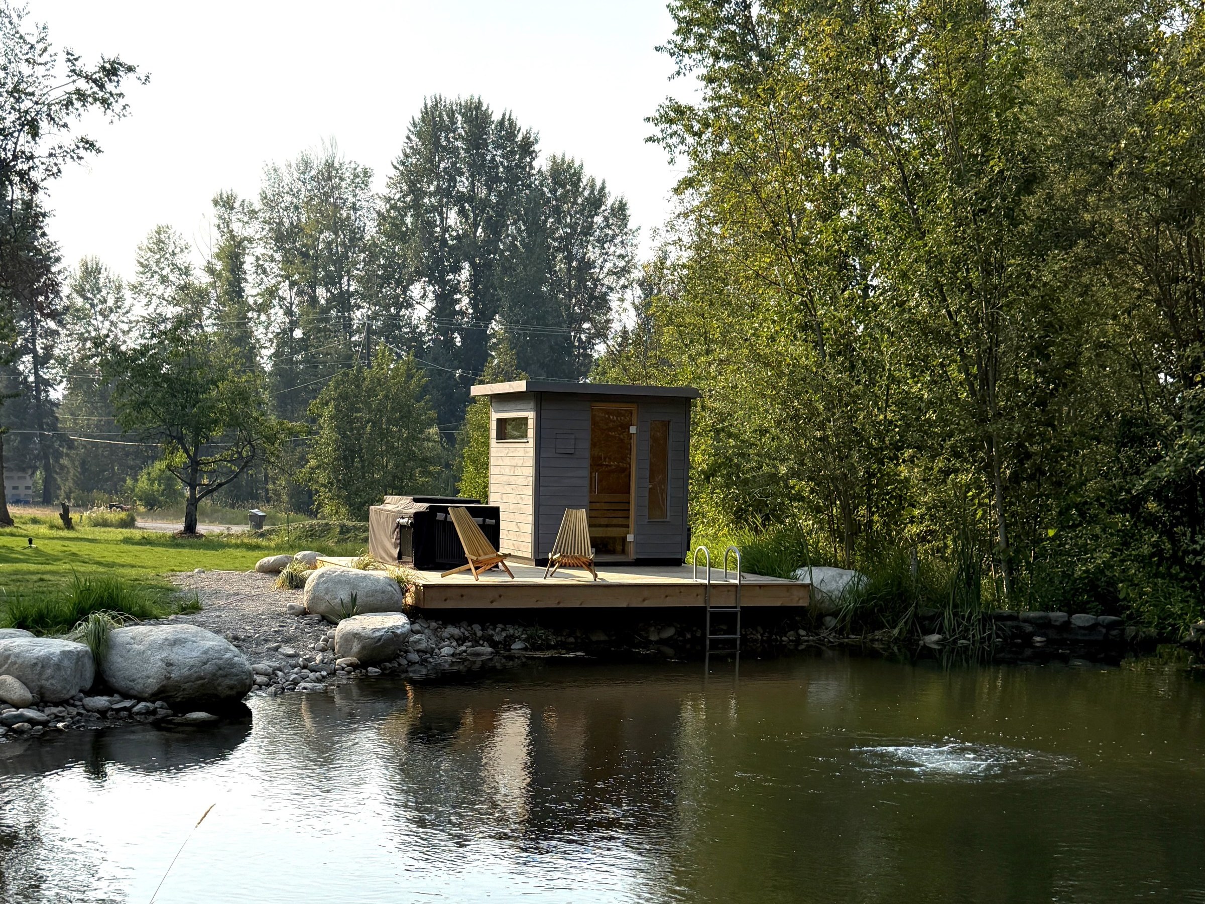 Sauna hut on its dock over the natural swimming pond