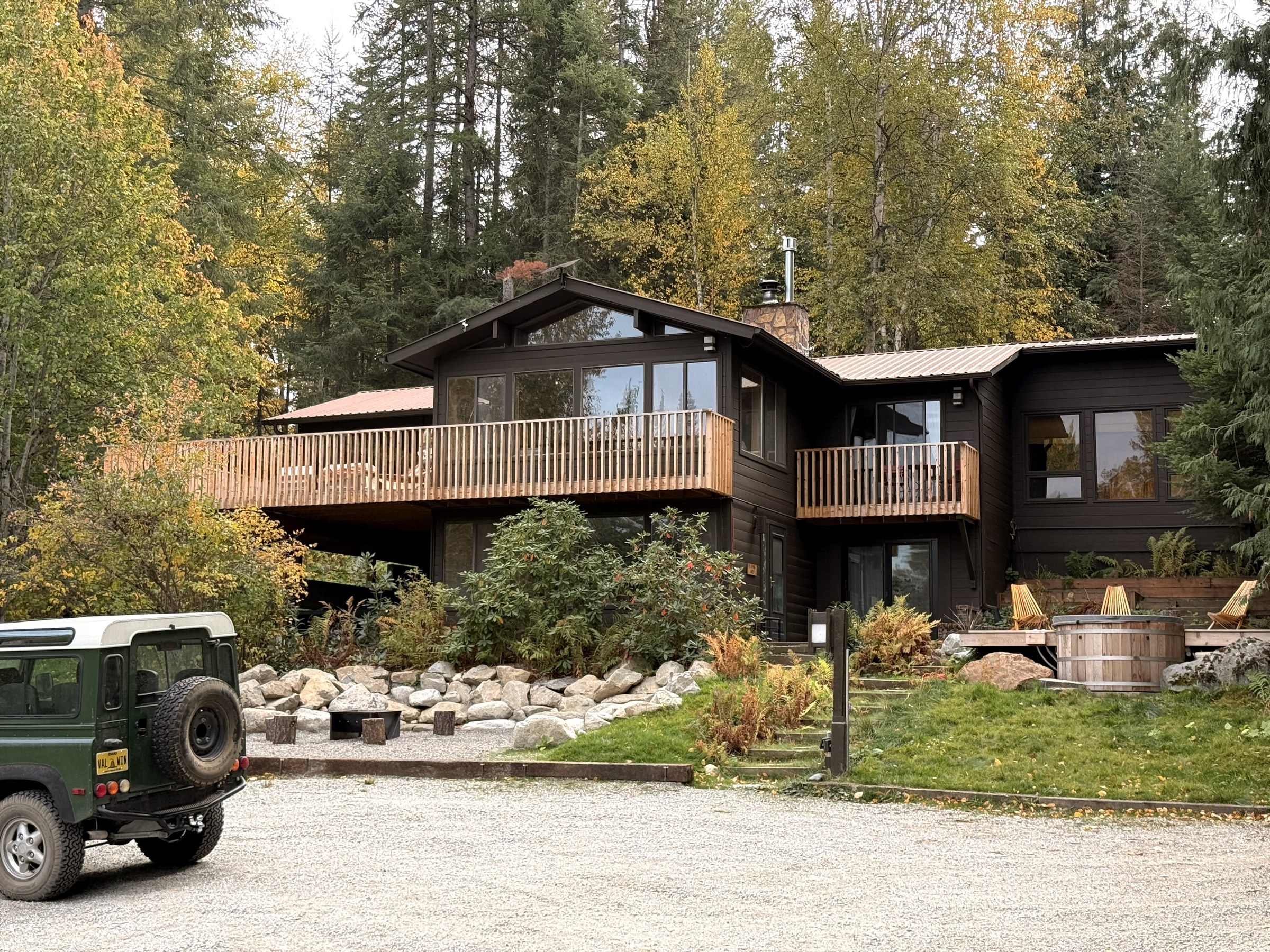 The cabin from the gravel drive, cedar hot tub on its deck